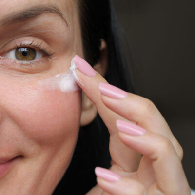 girl applies eye wrinkle cream